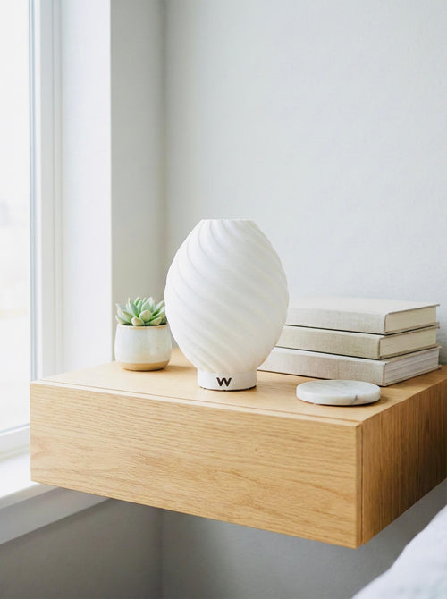 Modern spiral bedside lamp creating a warm, relaxing bedroom atmosphere