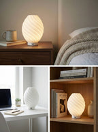 Minimalist spiral desk lamp providing soft mood lighting for a modern workspace