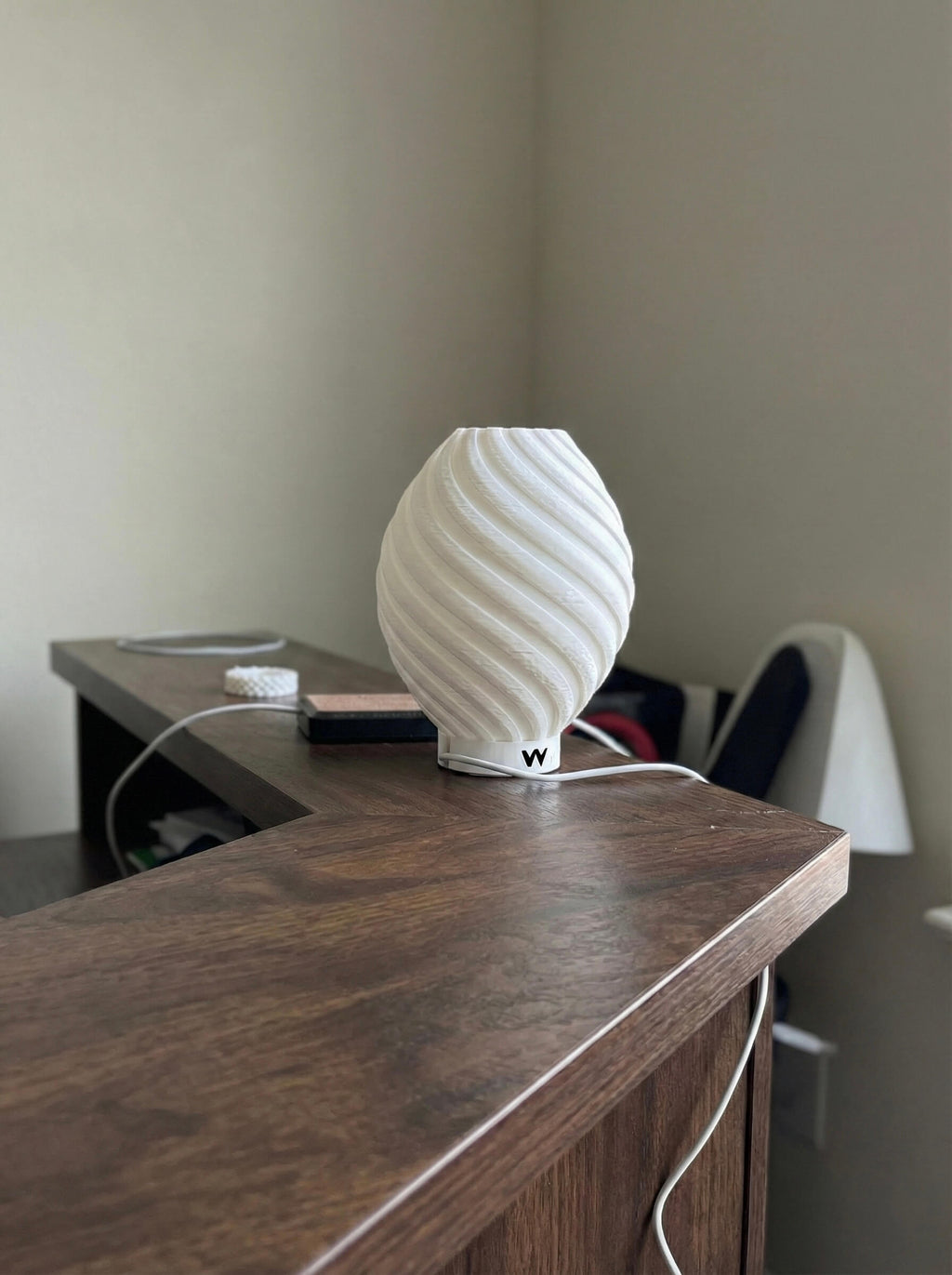 White textured lamp on a wooden surface with a neutral background